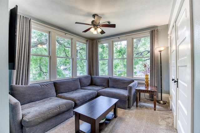 living room featuring light carpet, a ceiling fan, and a wealth of natural light