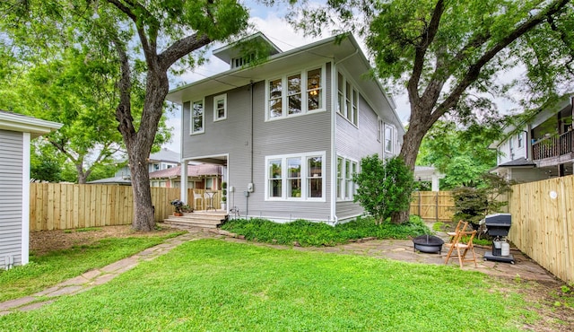 back of property with a yard and a fenced backyard