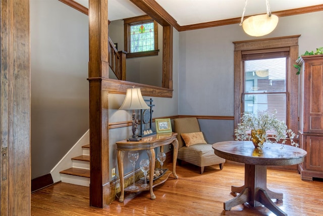 living area with stairs, baseboards, ornamental molding, and wood finished floors