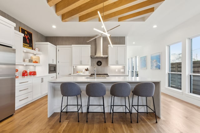 kitchen with open shelves, wall chimney range hood, light countertops, white cabinetry, and appliances with stainless steel finishes