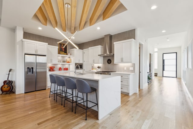 kitchen featuring wall chimney range hood, open shelves, a sink, stainless steel fridge with ice dispenser, and light countertops