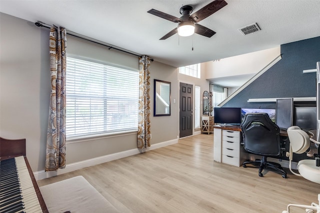 home office featuring baseboards, a ceiling fan, wood finished floors, and visible vents