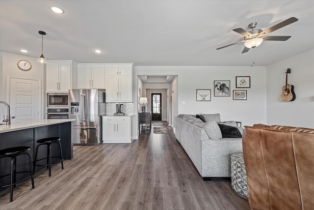 living area featuring recessed lighting, ceiling fan, and wood finished floors