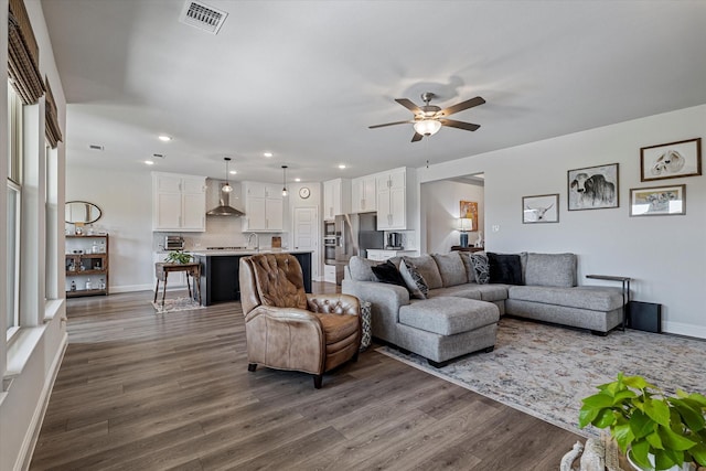 living room with a ceiling fan, visible vents, dark wood finished floors, baseboards, and recessed lighting