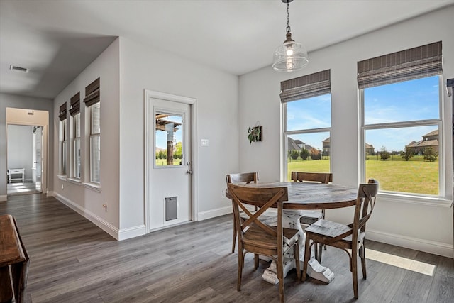 dining space with a healthy amount of sunlight, baseboards, dark wood-type flooring, and visible vents