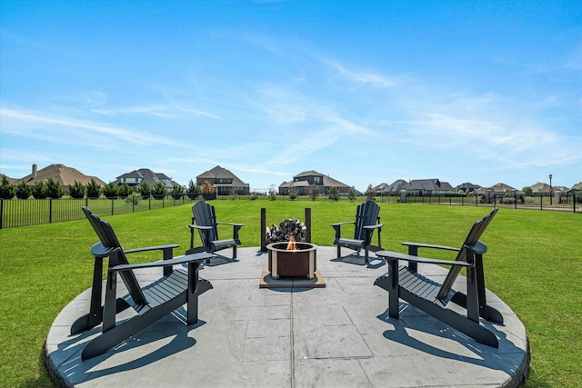 view of patio with an outdoor fire pit, fence, and a residential view