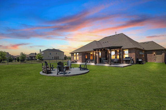 back of property at dusk featuring a yard, a pergola, fence, and a patio