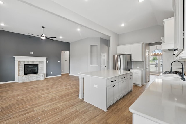 kitchen with freestanding refrigerator, light wood finished floors, ceiling fan, light countertops, and white cabinets