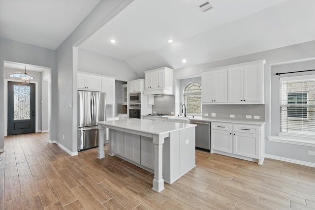 kitchen featuring baseboards, stainless steel appliances, white cabinetry, and visible vents