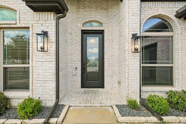 doorway to property with brick siding