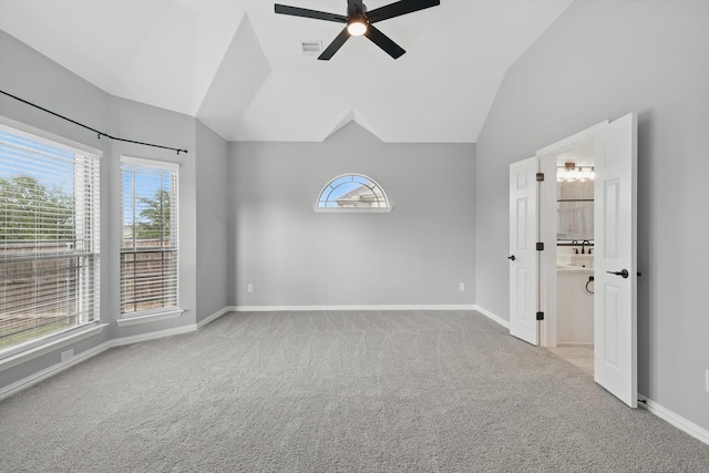 empty room featuring carpet, plenty of natural light, visible vents, and lofted ceiling