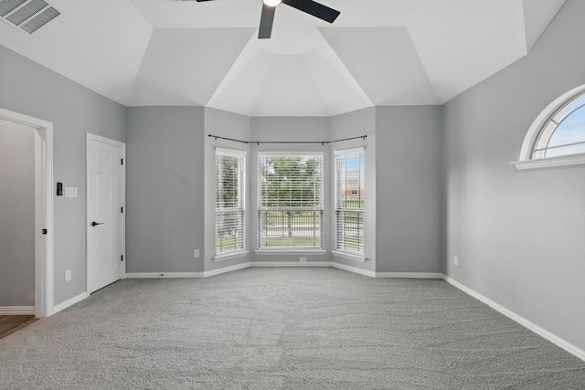 interior space featuring carpet, visible vents, vaulted ceiling, a ceiling fan, and baseboards