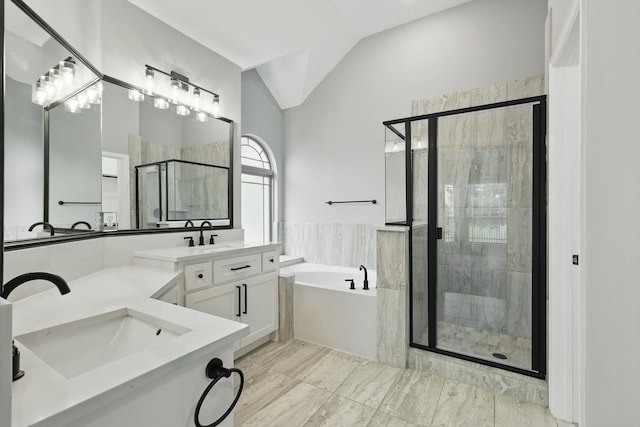 bathroom with lofted ceiling, a sink, a shower stall, a garden tub, and double vanity