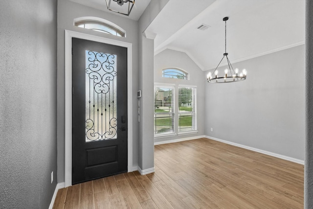 entrance foyer featuring lofted ceiling, a notable chandelier, light wood-style flooring, baseboards, and visible vents