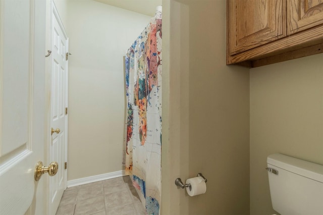 bathroom with a shower with curtain, tile patterned flooring, baseboards, and toilet