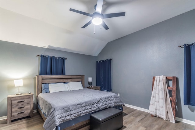 bedroom with baseboards, ceiling fan, wood finished floors, and lofted ceiling