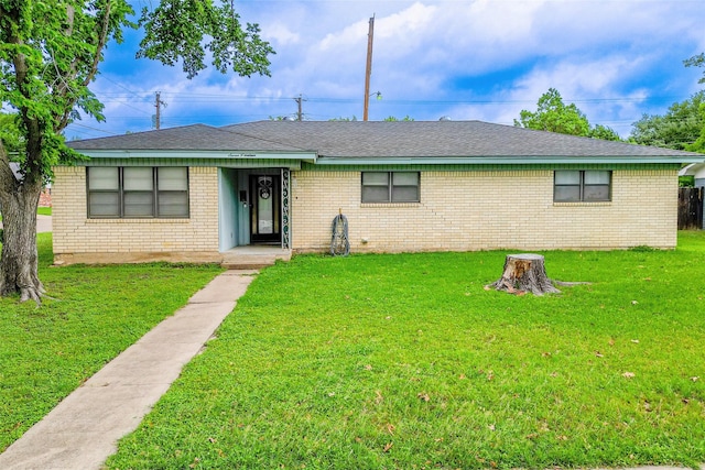 single story home featuring brick siding, a shingled roof, and a front yard