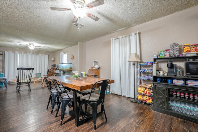 dining room with ceiling fan, dark wood finished floors, and a textured ceiling