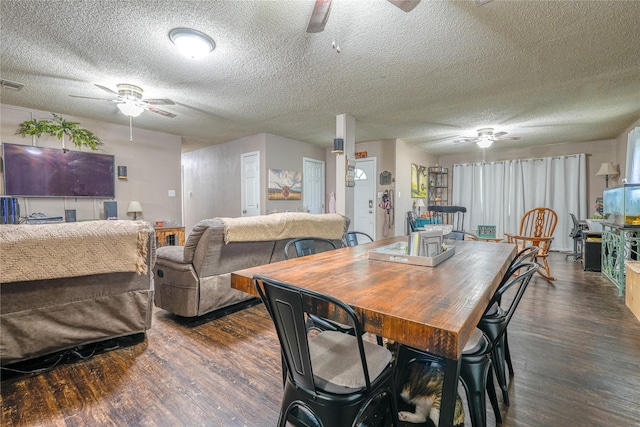 dining area featuring a textured ceiling, dark wood finished floors, and ceiling fan