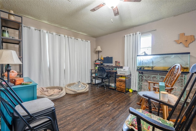 living area with ceiling fan, a textured ceiling, and wood finished floors