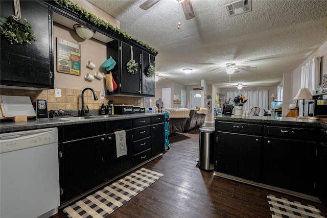 kitchen featuring dark cabinetry, white dishwasher, and a ceiling fan
