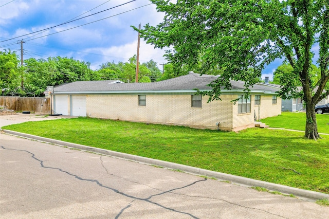 view of home's exterior featuring fence, an attached garage, brick siding, concrete driveway, and a lawn