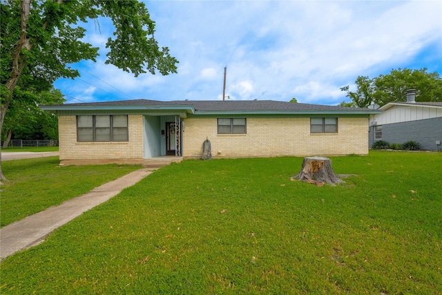 ranch-style house featuring brick siding and a front yard