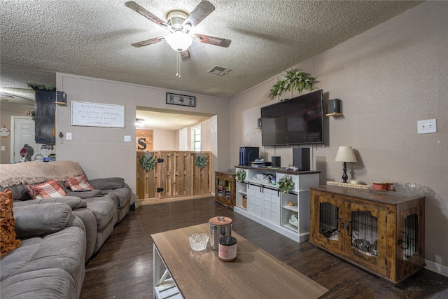 living area featuring visible vents, a ceiling fan, a textured ceiling, and wood finished floors