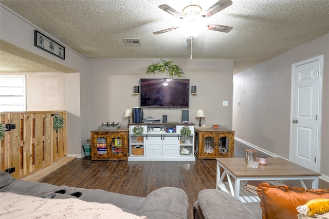 living area with a ceiling fan, baseboards, visible vents, and wood finished floors