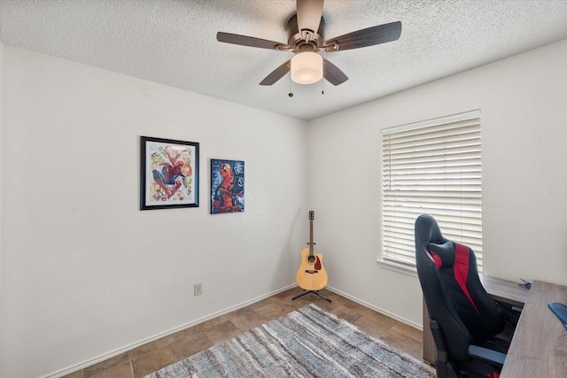 home office with a textured ceiling and ceiling fan