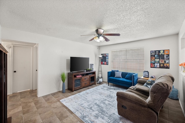 living area with a ceiling fan and a textured ceiling