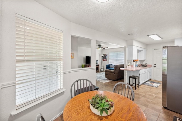 dining room with a ceiling fan and a textured ceiling