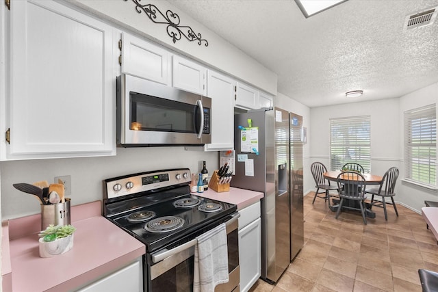 kitchen featuring visible vents, light countertops, a textured ceiling, and appliances with stainless steel finishes