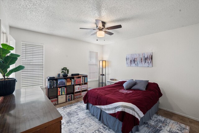 bedroom with two closets, a ceiling fan, a textured ceiling, and visible vents
