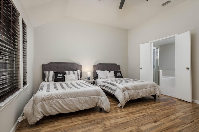 bedroom with visible vents, wood finished floors, connected bathroom, a ceiling fan, and vaulted ceiling