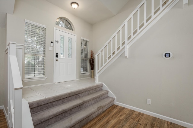 entryway with stairway, baseboards, and wood finished floors