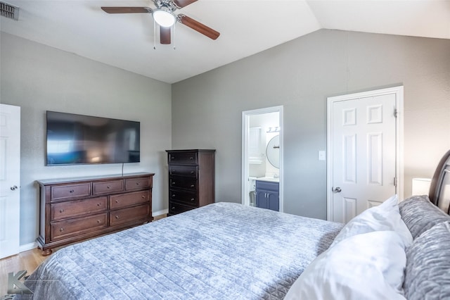 bedroom with ceiling fan, visible vents, wood finished floors, lofted ceiling, and ensuite bath