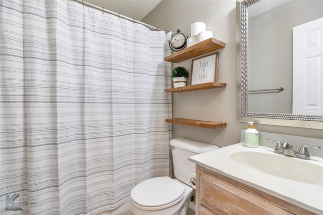bathroom featuring vanity, a textured wall, toilet, and curtained shower