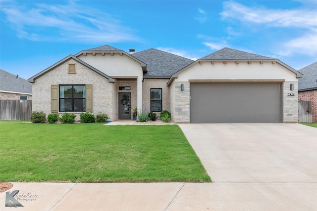 view of front facade featuring fence, a front yard, a shingled roof, an attached garage, and driveway