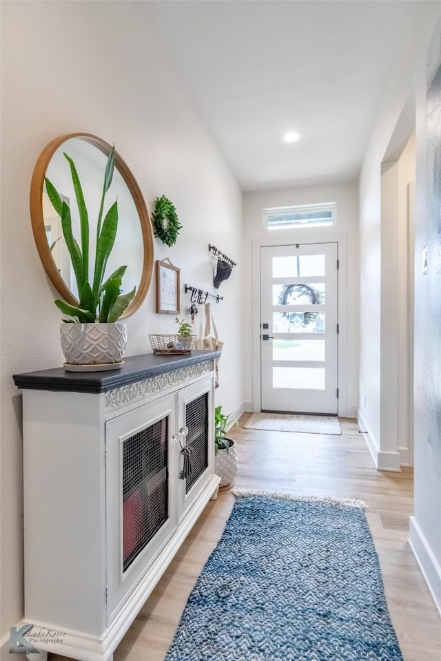 doorway featuring baseboards and light wood-type flooring
