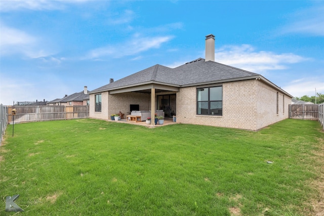 back of property featuring a fenced backyard, a chimney, brick siding, a patio area, and a lawn