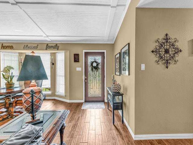 entrance foyer with crown molding, baseboards, and wood finished floors