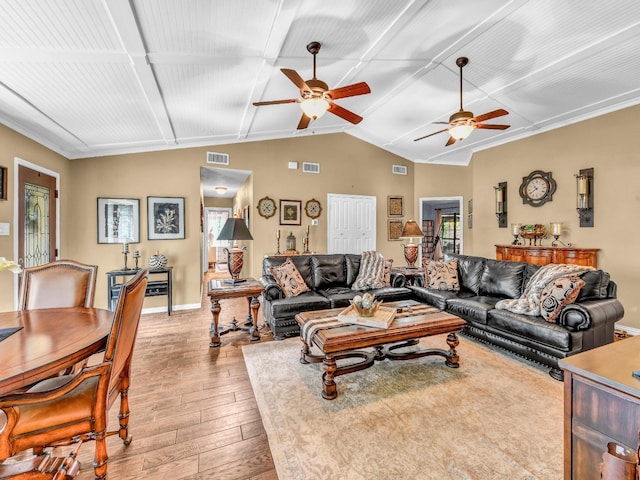living area with visible vents, baseboards, light wood-type flooring, a ceiling fan, and vaulted ceiling