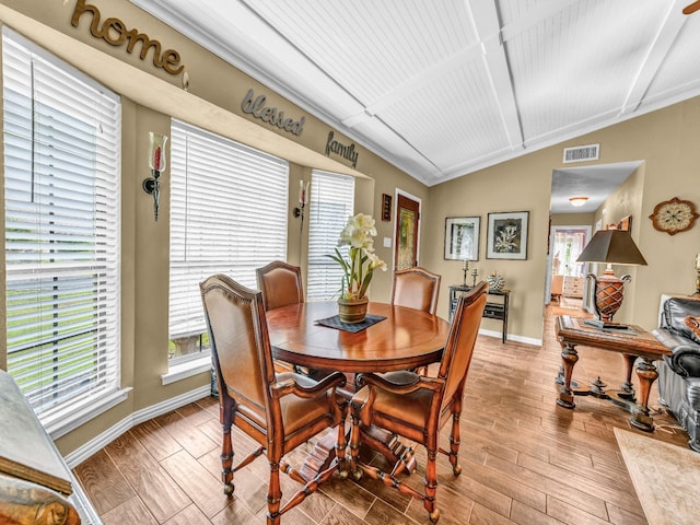 dining room featuring baseboards, wood finished floors, a wealth of natural light, and visible vents