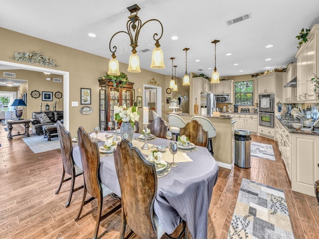 dining area featuring recessed lighting, light wood-style flooring, and visible vents