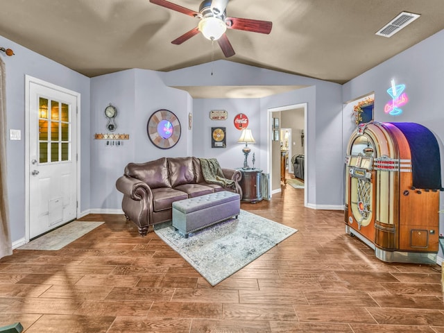 living room featuring visible vents, wood finished floors, baseboards, ceiling fan, and vaulted ceiling