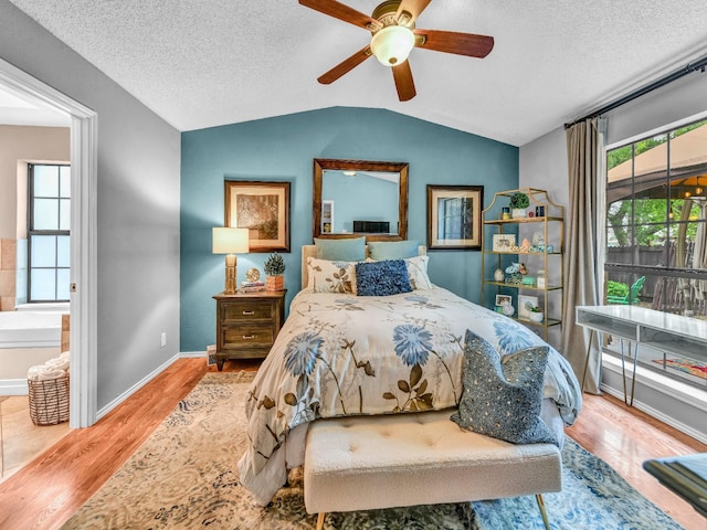 bedroom with wood finished floors, lofted ceiling, and multiple windows