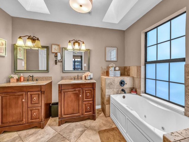 full bathroom with a tub with jets, a skylight, two vanities, and a sink