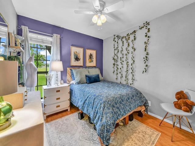 bedroom featuring baseboards, ceiling fan, and wood finished floors