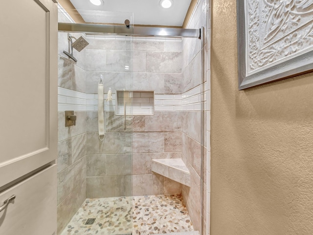 full bath with a textured wall, a tile shower, and recessed lighting